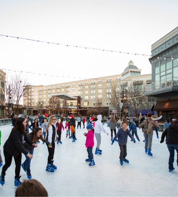 a group of people skating on an ice rink.