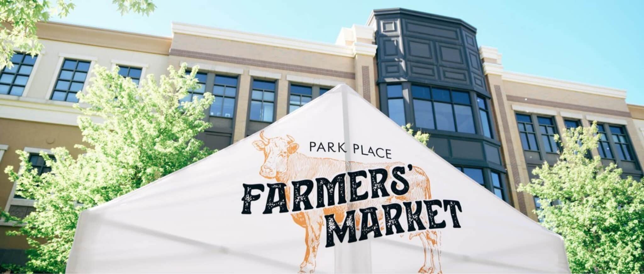 a farmers market sign in front of a building.